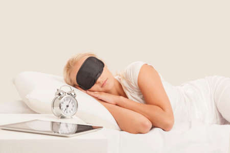 Pretty blonde young woman sleeps in her bedの写真素材