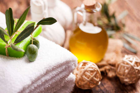 Olive oil soap and bath towel on wooden tableの写真素材