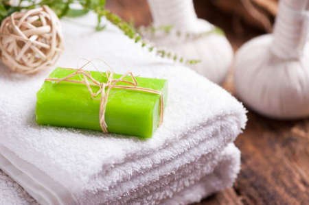 Bars of soap with fresh mint leaves and towels on wooden tableの写真素材