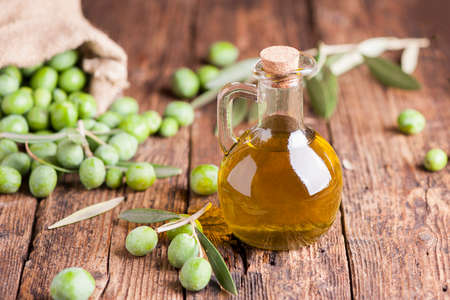 Olive oil and olives on wooden rustic tableの写真素材