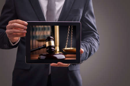 Composite image of man using tablet pc. Law and Justice conceptの写真素材