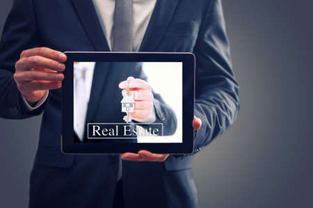Real Estate Agent man Showing Keys On Tabletの写真素材