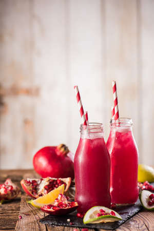 Cold transparent pomegranate drink on a wooden background. Selective focus.の写真素材
