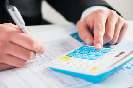 Accounting concept.Analyzing finance report with calculator