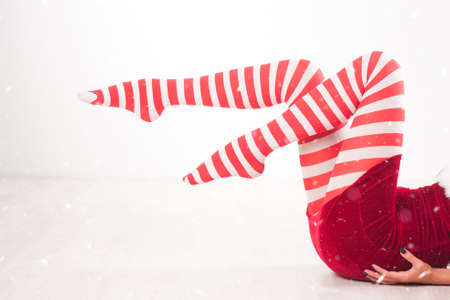 Woman in funny socks in the snow backgound. Christmas conceptの写真素材