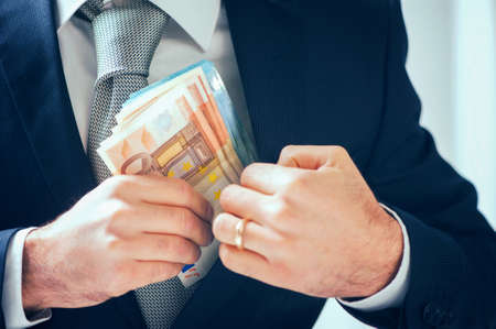 businessman putting money in his pocketの写真素材