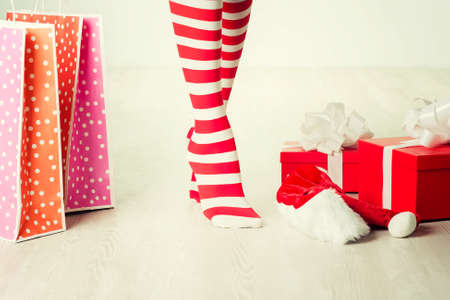Santa woman legs and gift. Christmas shopping conceptの写真素材