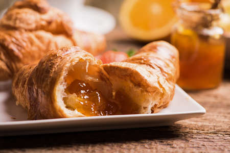 Croissants with orange marmallade on wooden backgroundの写真素材