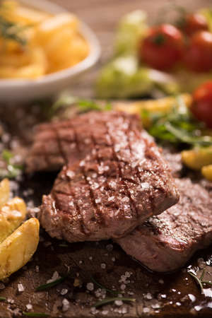 grilled meat with herbs on wooden boardの写真素材