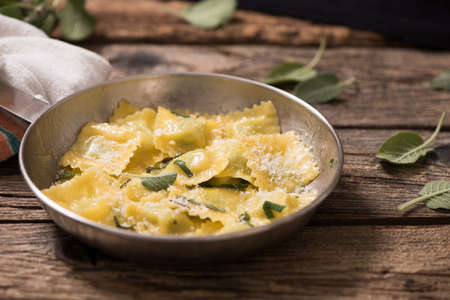 Italian cuisine: ravioli pasta with parmesan cheese and sageの写真素材