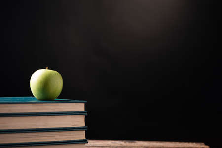 Green apple on books to a school centre. Back to school Concept