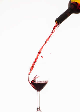 Red wine pouring down into a wine glassの写真素材