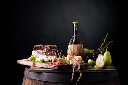 Flask of wine on a table with rustic traditional italian food.Fresh tipical italian lifestyleの写真素材