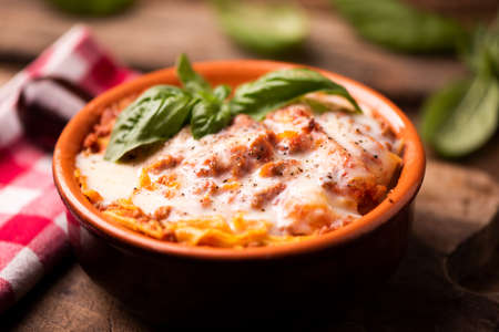 Traditional lasagne in a casserole dish on wooden tableの写真素材