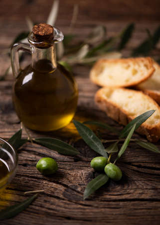 Olive oil with bread on a wooden table. Rustic  vintage composition