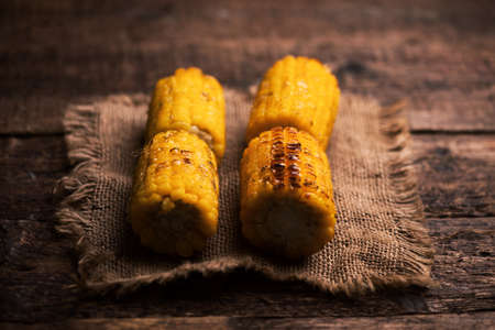 Grilled corn on wooden table. Close upの写真素材