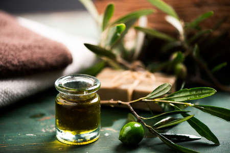 Natural spa with olive oil bar soap and towels onn a green wood vinatge tableの写真素材