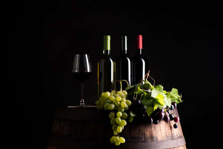 Mixes of bottle ow wine on barrel with grapeの写真素材