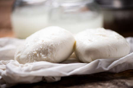Fresh mozzarella on white cloth with wooden backgroundの写真素材