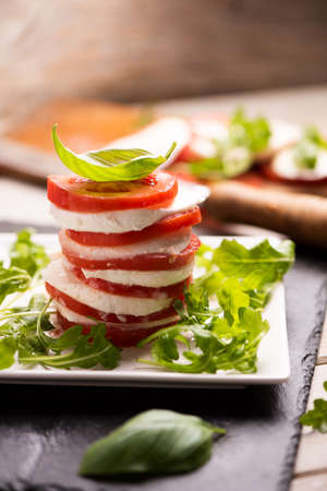 Fesh Italian Caprese salad with sliced mozzarella and herbs