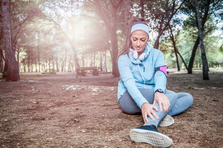Runner sport knee injury. Woman in pain while running in the park.の写真素材
