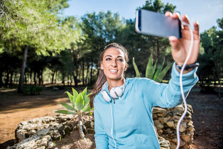Attractive girl making a selfie after her exercise in the parkの写真素材