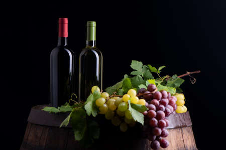 Wine bottles and a glass on a barrelの写真素材