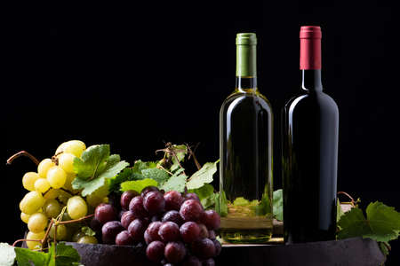 Wine bottles and a glass on a barrelの写真素材