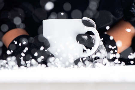 Cup of hot coffee in the hands in a cold dayの写真素材