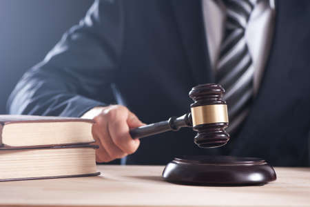 Hand of a judge holding a hammer or gavelの写真素材