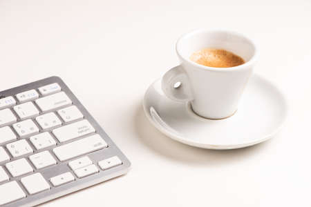 A close up view of arranged computer keyboard,cup of coffee on white table. Close upの写真素材