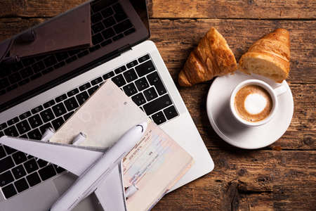 Passport with entry visa and, laptop model air plane and coffee. Travel conceptの写真素材