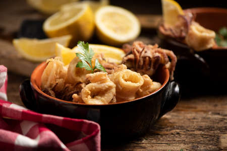 Traditional Italian fried calamari and lemon slice close upの写真素材
