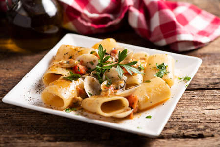Paccheri pasta with clams on white plate close upの写真素材