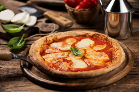 Italian pizza Margherita on a rustic wooden table. Close upの写真素材