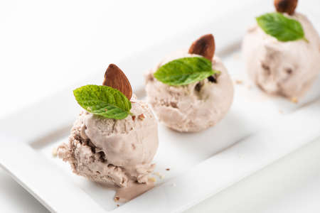 Hazelnut ice cream with nuts on a white plate and whiteの写真素材