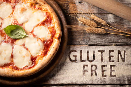 A gluten free pizza on  a rustic woodの写真素材
