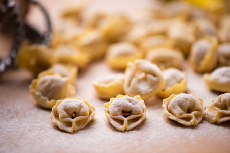 Tortellini or Tortelloni pasta on a flour dusted board close upの写真素材