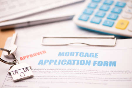 Approved mortgage loan agreement application with house shaped keyring close upの写真素材