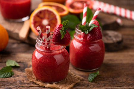 Strawberry smoothie in glass jar, over old wood table. close upの写真素材