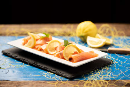Close up of smoked salmon on a plate  and a blue table の写真素材