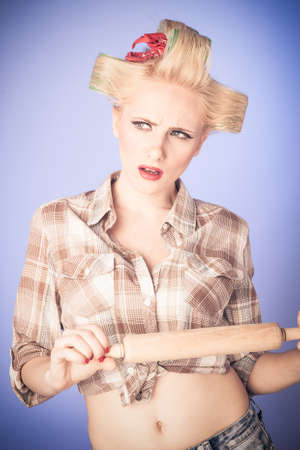 Pin up young housewife with rolling pin isolated on backgroundの写真素材