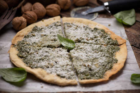 Pizza with pesto and parmesan cheese close up