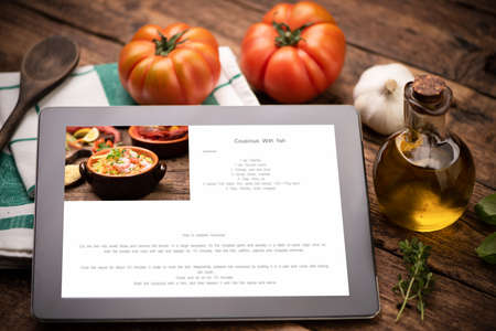 Food recipes tablet computer on rustic wooden table close upの写真素材