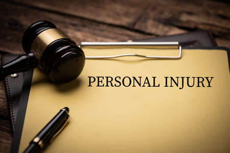 Personal Injury Law text on Document and gavel isolated on wooden office desk close upの写真素材