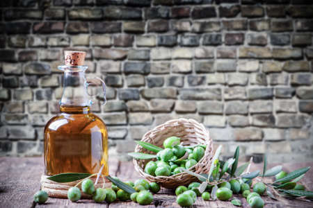 Olive oil and olive branch on the wooden table close upの写真素材