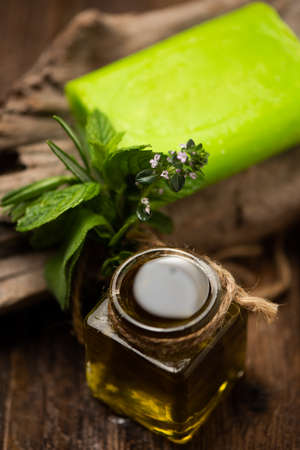 Organic oil with soap and rosemary and herbs close upの写真素材