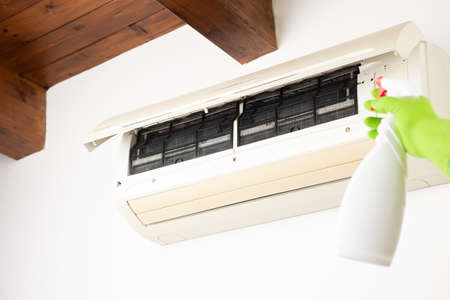 Hand cleaning air conditioner.Home work concept close upの写真素材