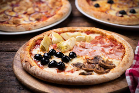 Pizza Four Seasons on wooden table close upの写真素材