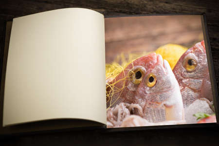 A vintage menu book and image as insert of a fresh fish